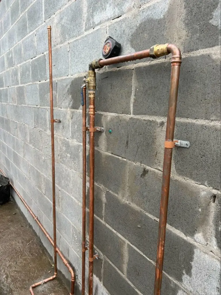 New copper water pipes fixed to a block wall