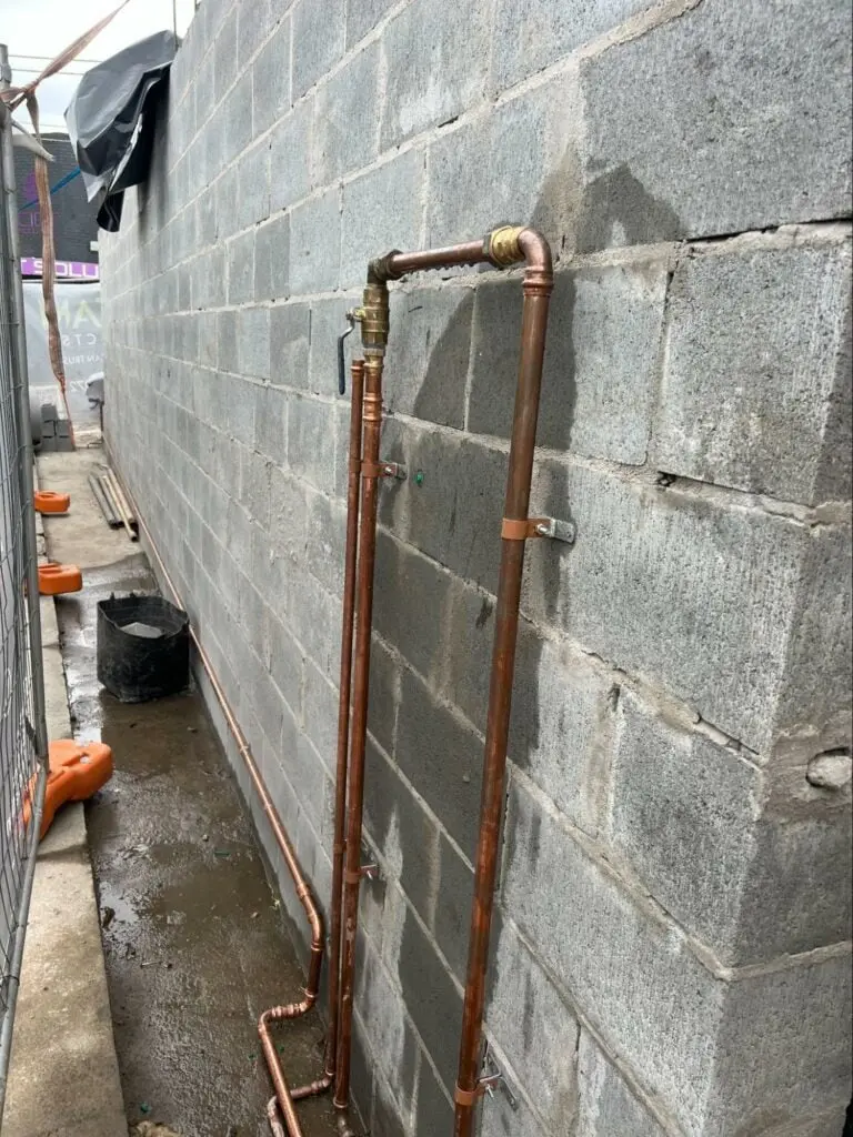 Replacement copper pipework running along an outside wall